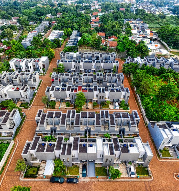 ours-journey A vibrant aerial view capturing the modern residential complexes in Banten, Indonesia, amidst lush greenery.